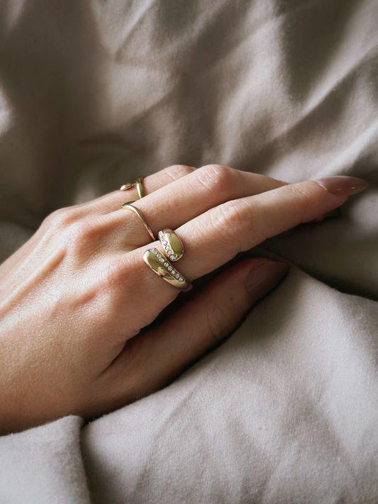 Chunky guldbelagt dråbering med små zirkoner. * Smuk og iøjnefaldene * Slidstærk og vandfast * En flot balance mellem trendy og klassisk Claire er en smuk, skulpturel tilføjelse til din smykkesamling. En ring til dig, der elsker chunky smykker med lidt kant. Claire-ringen er PVD-belagt og vandfast. Claire guldbelagt statementring med zirkoner · Chunky smykker