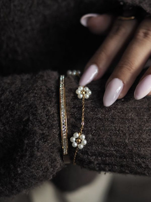 Smukt guldbelagt armbånd med 3 små perleblomster. Vandfaste smykker til kvinder. Budgetvenlige smykker til hverdag og gave. Guldbelagte smykker.