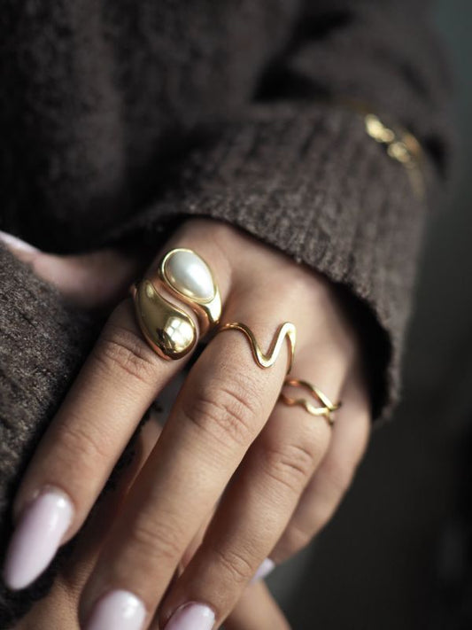 Aimée er en af vores mest populære guldringe, og vi forstår det godt. Den passer til alt og er smuk både i sig selv og matcher med andre smukke ringe.
Ringen har et blødt bølgemønster, som giver den et roligt og elegant udtryk. Designet er enkelt, men alligevel bemærkelsesværdigt.
Aimée er lavet i guldbelagt rustfrit stål med PVD-belægning.