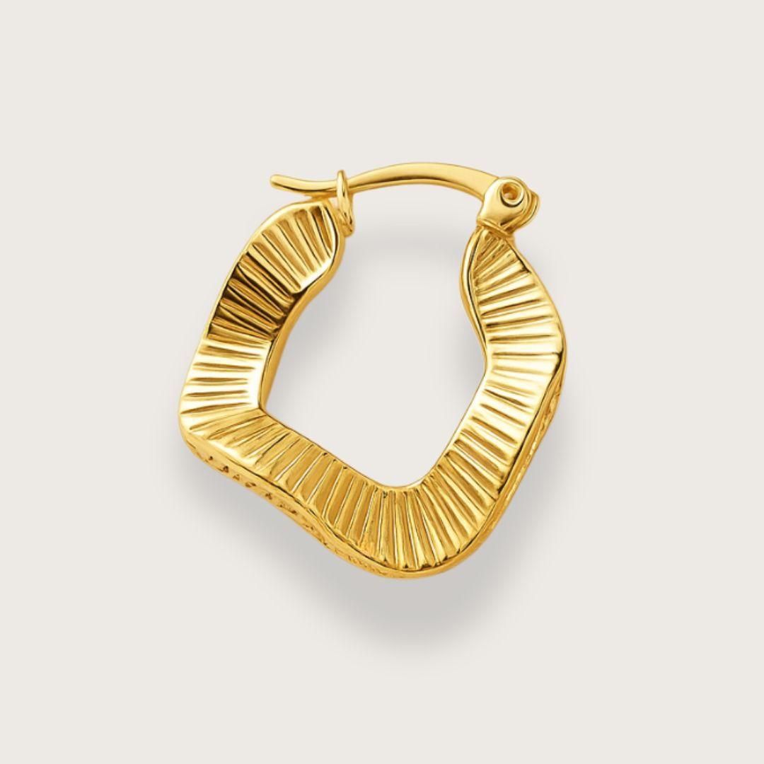 Guldbelagte wavy hoop øreringe. Vandfaste hoop oreringe i rustfrit staal med 18K forgyldning. Ottilie hoop-øreringe fra Chant du Matin. Boelget firkantet design med riflede detaljer og click-down laas. Nikkelfri, blyfri og perfekte som gave.