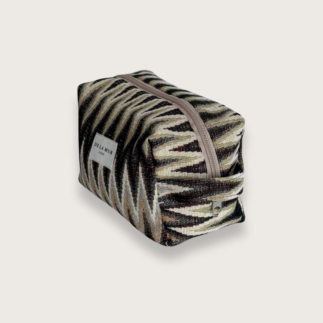 Rummelig makeuptaske i smukt jacquardstof – Toilettasker til kvinder. En skøn lille toilettaske, der rummer alt det nødvendige. Toilettasken er syet i kraftigt bomuldsstof med smukt zigzagmønster. Designet og syet i Spanien.