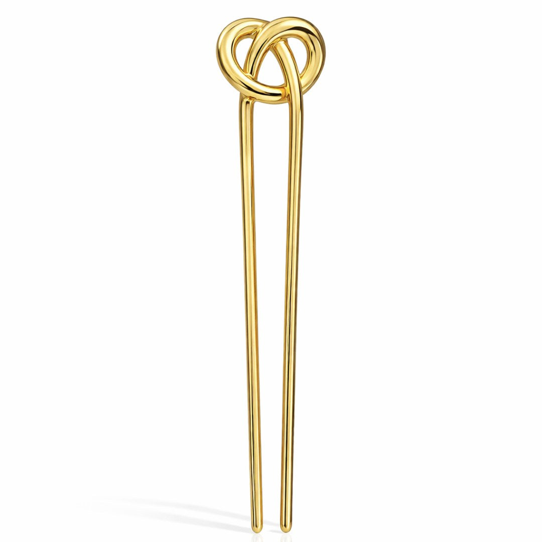 Cady er en elegant fransk hårnål med et skulpturelt og enkelt udtryk, hvor den dekorative knude i toppen giver et diskret, men iøjnefaldende twist. Den glatte, guldfarvede overflade reflekterer lyset smukt og tilfører et eksklusivt præg, uanset om håret er sat op eller bæres mere løst og afslappet.
Hårnålen er fremstillet i guldfarvet metal og måler ca. 12,3 cm i længden og ca. 3 cm i bredden ved toppen, og med en vægt på ca. 27 g føles den solid og behagelig i håret. fransk hårnål guld