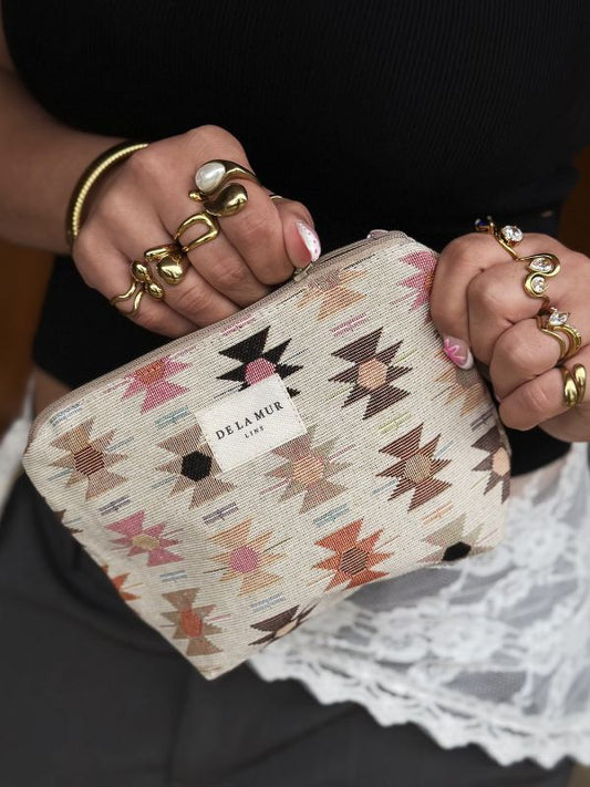 Lille toilettaske i beige stof med lynlås og lyserødt håndtag
Den perfekte lille "touch up bag" til skoletasken.
En sød og praktisk lille makeuptaske i beige stof med elegant mønster i smukke, afdæmpede farver.
Denne toilettaske rummer hverdagsmakeuppen og de små favoritter, du har brug for at have lige ved hånden i løbet af dagen eller hjemme på badeværelset.
Makeuptasken er fremstillet af lækkert jacquardvævet bomuldsstof og foret med slidstærkt, gråt stof på indersiden.