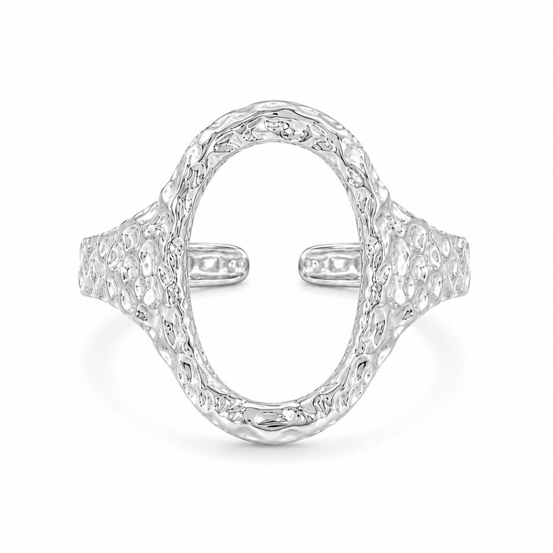 Sølvbelagt oval ring i rustfrit stål med banket overflade
Elvira-ringen er designet med en markant organisk silhuet og en åben oval front, der giver ringen et mere skulpturelt udtryk end klassiske sølvringe. Den hamrede overflade skaber ujævne refleksioner i metallet og giver ringen mere dybde, struktur og karakter fra alle vinkler.
Elvira er en sølvring, der tilfører form, struktur og mere kant til selv en enkel styling.
Ringen er fremstillet i stål med vandfast PVD-sølvbelægning.
oval sølvring