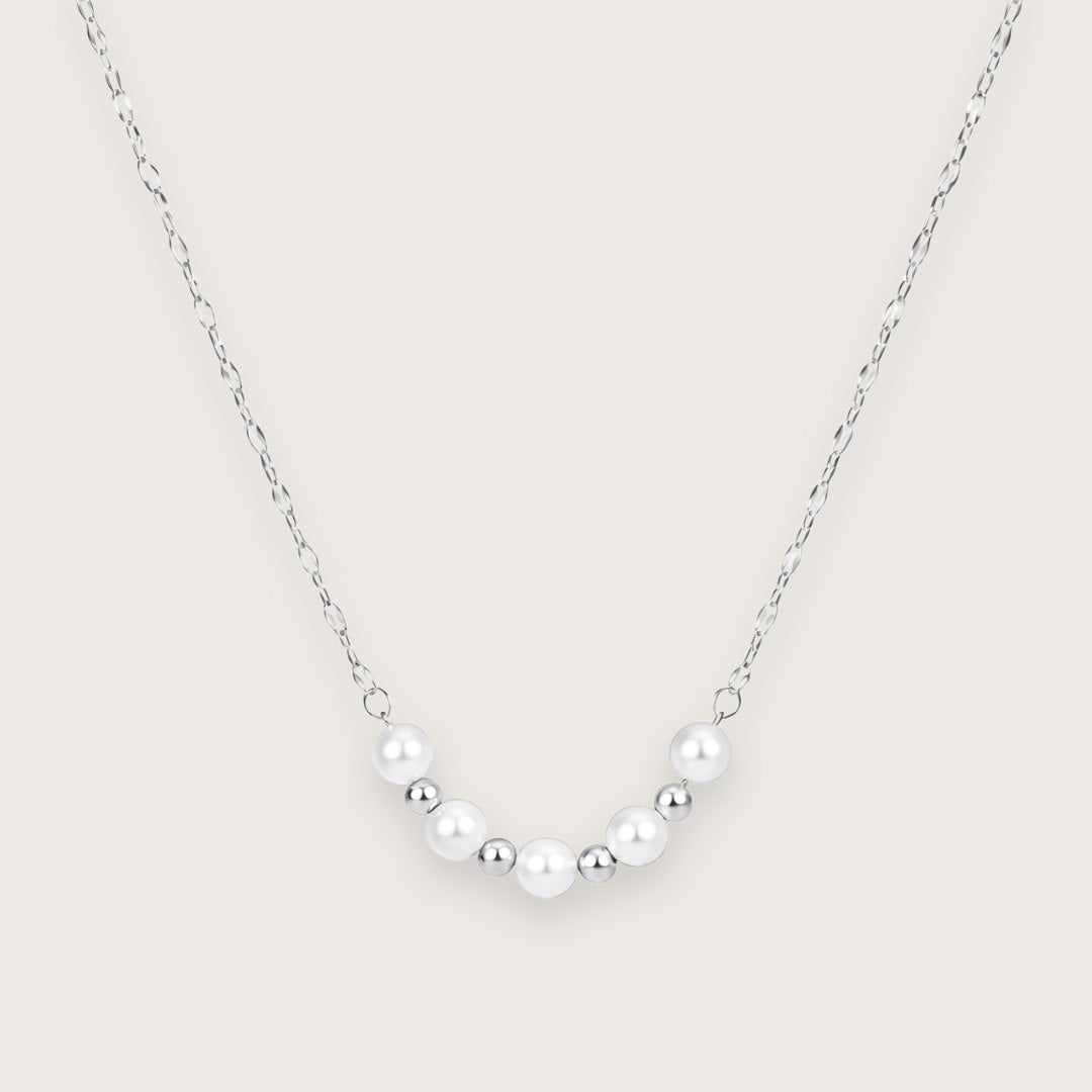 Smuk og klassisk halskæde med perler.
Den elegante Alva halskæde i sølvtonet rustfrit stål kombinerer det klassiske perlelook med en moderne lipchain-kæde, der stacker flot med andre sølvhalskæder.
De små kugledetaljer i sølv og de fine perler giver halskæden et let og feminint udtryk, der fungerer både alene og sammen med andre guldhalskæder og perlesmykker.
Halskæden er fremstillet i sølvtonet rustfrit stål, hvilket gør smykket velegnet til daglig brug.
