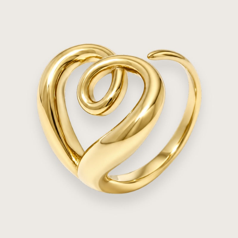 Millie 18k forgyldt ring med diskret hjerteform

Skulpturel ring i guldbelagt rustfrit stål med et organisk, snoet design. Kigger du efter, gemmer der sig et hjerte i formen, men i modsætning til mere hjerteringe er Millie mere cool end cute.

Millie-ringen er justerbar, PVD-forgyldt og vandfast.

En ring med blikfang og lidt kant, der er perfekt til stacking med andre guldringe, men sagtens kan bære looket alene.&nbsp;