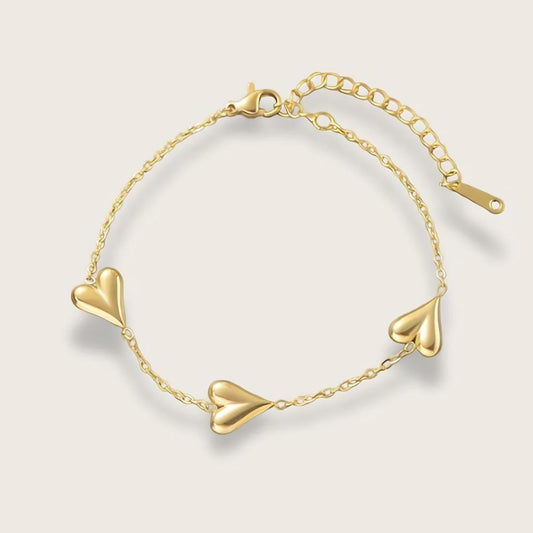 18k forgyldt hjertearmbånd med vandfast PVD-belægning

Inès hjertearmbåndet er et klassisk smykke med moderne kant til de dage, hvor du lige vil udstråle dét ekstra.&nbsp;

Det tynde armbånd og hjerternes tyngde skaber en elegant kontrast, der kan løfte ethvert outfit.

Inés-armbåndet findes også som halskæde.

Armbåndet er 18k PVD-belagt og er derfor både vandfast og ridsefast.&nbsp;
Mål: 17 cm + 5 cm. Justerbart.