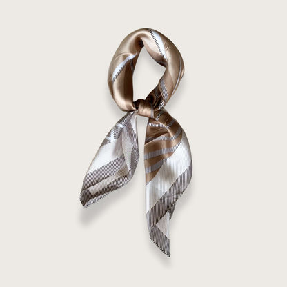 Kvadratisk tørklæde i brune og beige nuancer og smukt mønster.

Tørklædets elegante mønster giver mulighed for mange forskellige udtryk, alt efter hvordan man vælger at folde og binde tørklædet.

Klassiske, kvadratiske tørklæder kan bruges på utallige måder. Bind tørklædet om håret, brug det som en smuk detalje på tasken, som pandebånd, som klassisk tørklæde om halsen, eller gør lidt ekstra ud af frisuren ved at binde tørklædet om din knold eller hestehale.

Satintørklæder er et must i enhver garderobe.