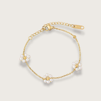 Klassisk guldbelagt armbånd med tre små perleblomster. Et smukt og elegant blomsterarmbånd til kvinder - en oplagt gaveidé til din veninde, søster eller mor.