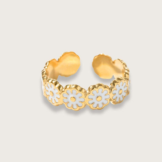 Smuk og enkel guldbelagt ring med hvide emaljeblomster og vandfast PVD-belægning. Iris emaljeringen er velegnet som hverdagsring, da den er både vandfast og slidstærk. 