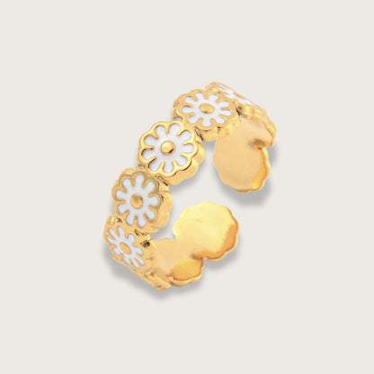 Smuk og enkel guldbelagt ring med hvide emaljeblomster og vandfast PVD-belægning. Iris emaljeringen er velegnet som hverdagsring, da den er både vandfast og slidstærk. 