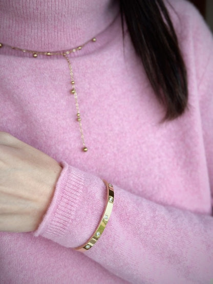 Smuk guldbelagt halskæde med elegante små kuglevedhæng.

Trendy Y-halskæde med kugle-design
Vandfast og slidstærk guldbelægning
En halskæde, der kan dresse ethvert outfit op

Isabel Halskæden med de små gyldne dangling dots er en elegant og let kæde, der giver et blødt, feminint udtryk.

Det enkle kugledesign gør den super nem at style med andre guldhalskæder.