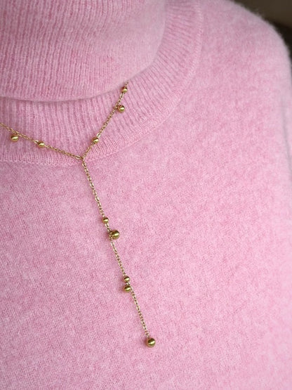 Smuk guldbelagt halskæde med elegante små kuglevedhæng.

Trendy Y-halskæde med kugle-design
Vandfast og slidstærk guldbelægning
En halskæde, der kan dresse ethvert outfit op

Isabel Halskæden med de små gyldne dangling dots er en elegant og let kæde, der giver et blødt, feminint udtryk.

Det enkle kugledesign gør den super nem at style med andre guldhalskæder.