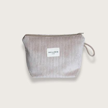 Lille toilettaske eller makeuptaske med lynlås øverst og beige snorhåndtag på siden. Lavet af tykt beige fløjlstof. Fra spanske De la Mur. Unisex. Toilettaske til mænd. Toilettaske til kvinder.