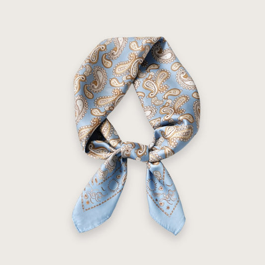 Lucy satintørklædet har et klassisk paisleymønster i afdæmpede nuancer, der giver et blødt og tidløst udtryk. Farven er let og klar, mens satinen tilfører en diskret glans, som minder om silke og falder smukt, når tørklædet bindes.

Det lyseblå satintørklæde er særligt velegnet til forår og sommer, hvor lette materialer og klare farver gør en forskel i hverdagen. Den glatte satin føles luftig mod huden og er behagelig at bære, også på varmere dage. 

Silketørklæde, satin tørklæde, kvadratisk satintørklæde
