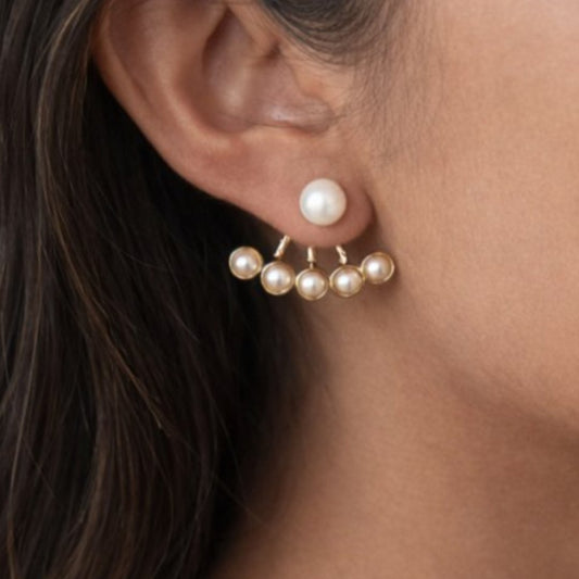 Smukke forgyldte perleøreringe i trendy to-lags-design.

Felicity er et par perleøreringe med et smukt, iøjnefaldende design, der går både foran og bag øret.

Foran øret sidder en enkelt, klassisk perle, og bag øret er der en elegant vifte af mindre perler, der&nbsp; følger ørets form. Det skaber et lagdelt udtryk, der ses fra flere vinkler og giver smykket karakter uden ekstra volumen.
