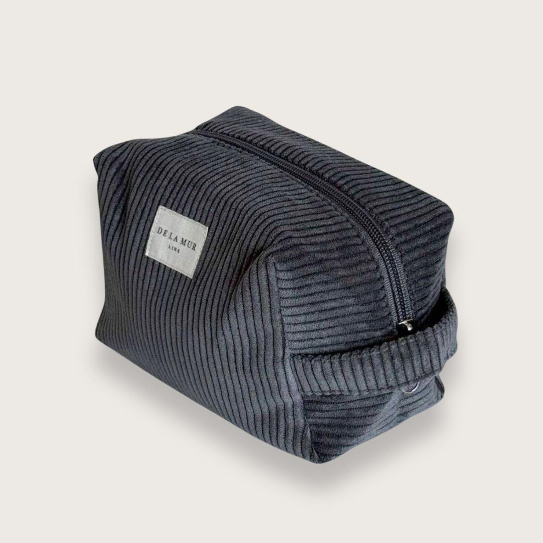 Toilettaske til kvinder. Makeuptaske. Rummelig toilettaske. Lille og rummelig toilettaske i mørkegråt fløjl fra det lille spanske mærke De la Mur.&nbsp;  En blød, rummelig og virkelig pæn lille toilettaske, der rummer meget mere, end man skulle tro.&nbsp;  Toilettasken er syet i tykt og luksuriøst fløjl og har et enkelt, men gennemført udtryk, så du får lyst til at have stående fremme.