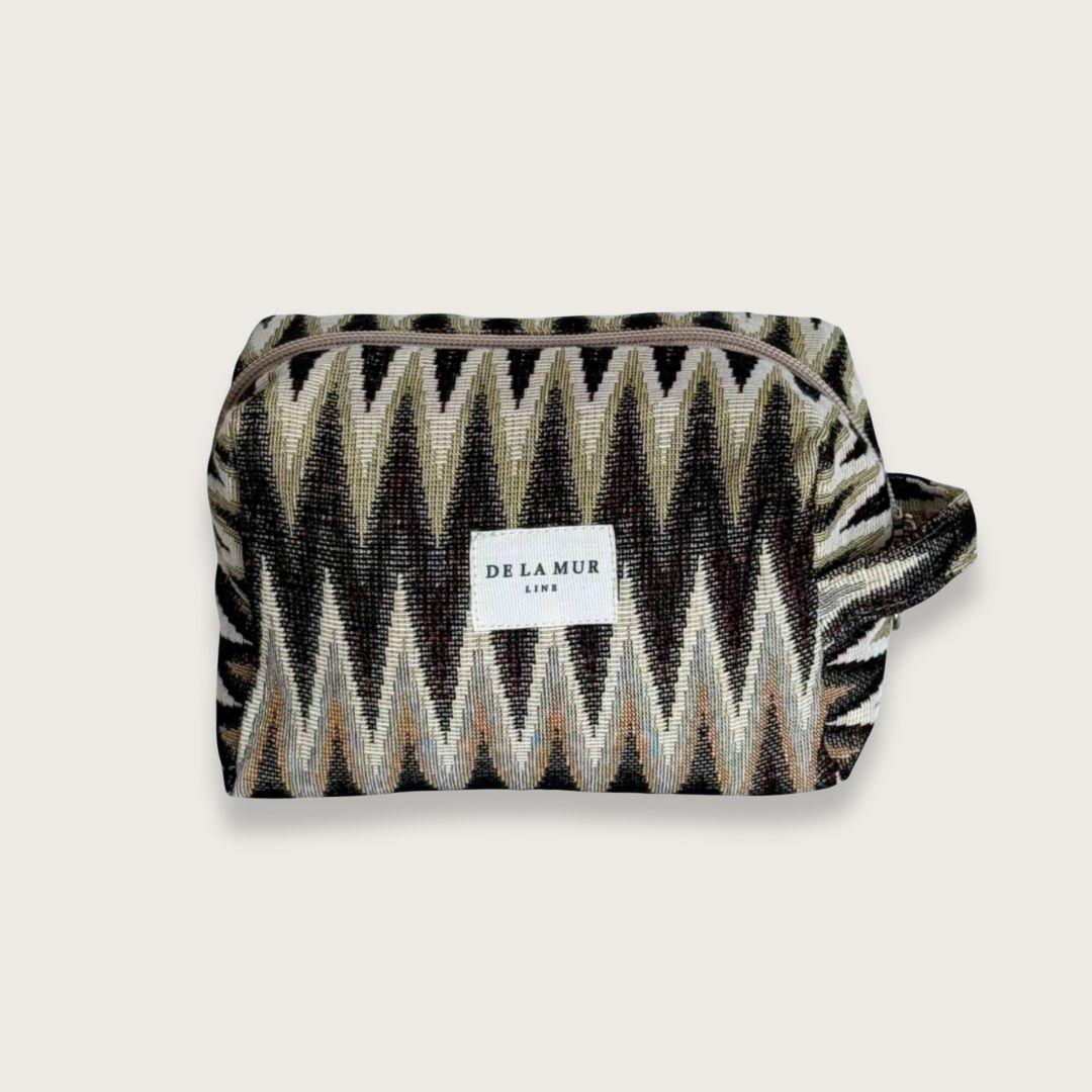 Rummelig makeuptaske i smukt jacquardstof – Toilettasker til kvinder. En skøn lille toilettaske, der rummer alt det nødvendige. Toilettasken er syet i kraftigt bomuldsstof med smukt zigzagmønster. Designet og syet i Spanien. 