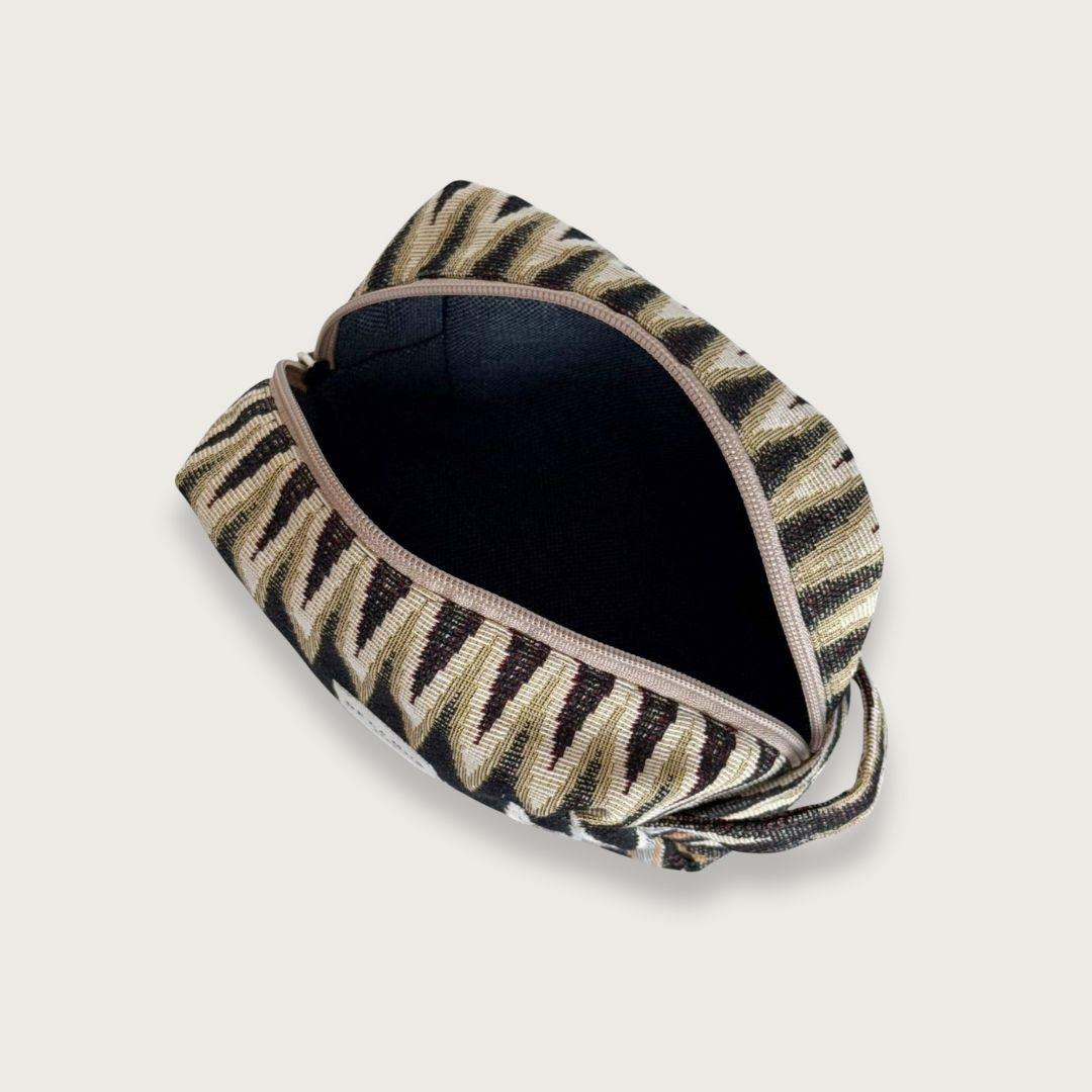 Rummelig makeuptaske i smukt jacquardstof – Toilettasker til kvinder. En skøn lille toilettaske, der rummer alt det nødvendige. Toilettasken er syet i kraftigt bomuldsstof med smukt zigzagmønster. Designet og syet i Spanien. 