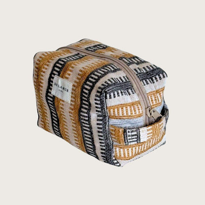 En skøn lille toilettaske, der rummer alt det nødvendige. Toilettasken er syet i blødt gråt fløjl og har et praktisk sidehåndtag. Designet og syet i Spanien. Makeuptasker. Gaveidé til veninde.