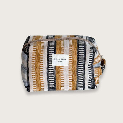 En skøn lille toilettaske, der rummer alt det nødvendige. Toilettasken er syet i blødt gråt fløjl og har et praktisk sidehåndtag. Designet og syet i Spanien. Makeuptasker. Gaveidé til veninde.