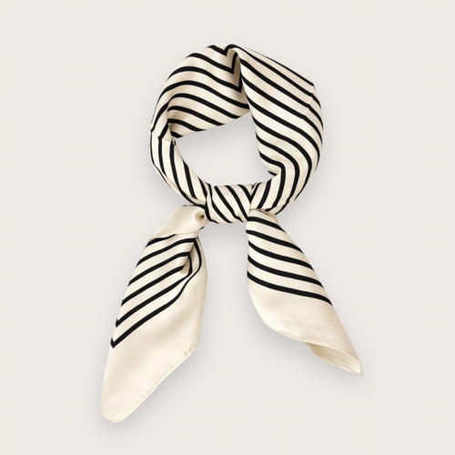 Ory er et smukt og stilrent satintørklæde med sorte striber på en lys, cremefarvet baggrund.&nbsp;

Udtrykket er minimalistisk med et fashion-forward twist på det klassiske silketørklæde og fungerer perfekt som det lille ekstra, der samler outfittet. Et kvadratisk tørklæde i satin, der er nemt at style både casual med jeans og tee – eller mere polished med blazer og solbriller.