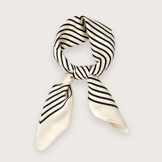 Ory er et smukt og stilrent satintørklæde med sorte striber på en lys, cremefarvet baggrund.&nbsp;

Udtrykket er minimalistisk med et fashion-forward twist på det klassiske silketørklæde og fungerer perfekt som det lille ekstra, der samler outfittet. Et kvadratisk tørklæde i satin, der er nemt at style både casual med jeans og tee – eller mere polished med blazer og solbriller.