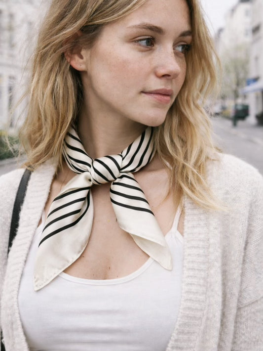 Ory er et smukt og stilrent satintørklæde med sorte striber på en lys, cremefarvet baggrund.&nbsp;

Udtrykket er minimalistisk med et fashion-forward twist på det klassiske silketørklæde og fungerer perfekt som det lille ekstra, der samler outfittet. Et kvadratisk tørklæde i satin, der er nemt at style både casual med jeans og tee – eller mere polished med blazer og solbriller.