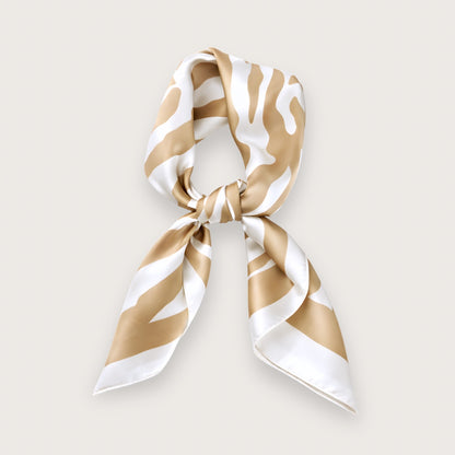 Maeve satintørklædet er et kvadratisk trendy cremefarvet tørklæde med sandfarvede zebrastriber, der giver et blødt og diskret udtryk, man normalt ikke forbinder med dyreprint.

Satinen tilfører en glans, som minder om silke og falder smukt, når satintørklædet bindes.

De sandfarvede zebrastriber, der spåes at blive store i foråret/sommeren 2026, er nemt at style. Tørklædets udtryk ændrer sig, alt efter hvordan det bindes. 

Satin tørklæde, silketørklæde, tørklæder til forår og sommer.