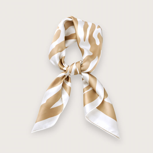 Maeve satintørklædet er et kvadratisk trendy cremefarvet tørklæde med sandfarvede zebrastriber, der giver et blødt og diskret udtryk, man normalt ikke forbinder med dyreprint.

Satinen tilfører en glans, som minder om silke og falder smukt, når satintørklædet bindes.

De sandfarvede zebrastriber, der spåes at blive store i foråret/sommeren 2026, er nemt at style. Tørklædets udtryk ændrer sig, alt efter hvordan det bindes. 

Satin tørklæde, silketørklæde, tørklæder til forår og sommer.