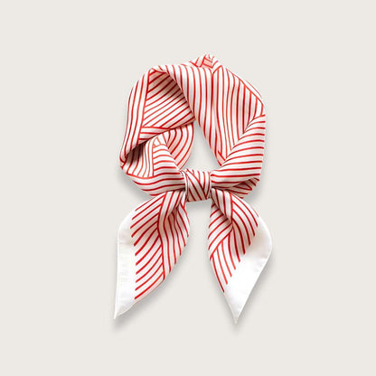 Silketørklæde i prisvenlig satin med geometrisk stregmønster i rød og hvid. Fremstillet af polyester. Kan håndvaskes. Kvadratisk satintørklæde til kvinder.