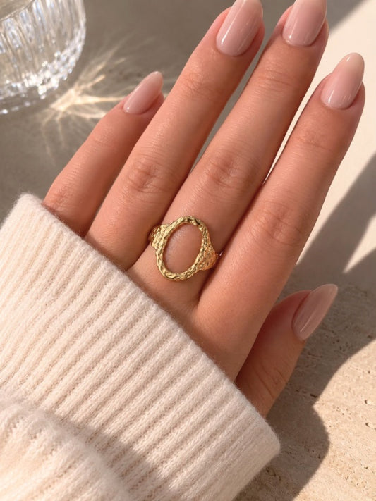Forgyldt oval ring i rustfrit stål med banket overflade

Elvira-ringen er designet med en markant organisk silhuet og en åben oval front, der giver ringen et mere skulpturelt udtryk end klassiske guldringe. Den hamrede overflade skaber ujævne refleksioner i metallet og giver ringen mere dybde, struktur og karakter fra alle vinkler.

Elvira er en guldring, der tilfører form, struktur og mere kant til selv en enkel styling.

Ringen er fremstillet i rustfrit stål med vandfast PVD-forgyldning

oval ring