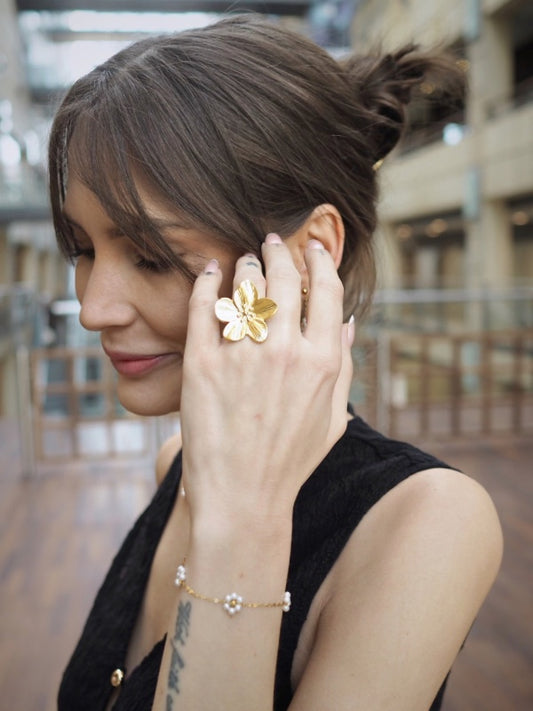 Smuk blomsterring i 18k forgyldt stål

Den smukke Nell guldring er et moderne statement-smykke med en skulpturel blomsterform. Den store blomst giver ringen et markant og eksklusivt udtryk, der kan give et strejf af sommer til ethvert outfit – og enhver dag.

Ringen er fremstillet i rustfrit stål med 18k PVD-forgyldning, som giver en slidstærk guldoverflade og gør smykket mere modstandsdygtigt over for daglig brug.

Kombinationen af rustfrit stål og PVD-belægning gør ringen til et godt valg, hvis du foretræ