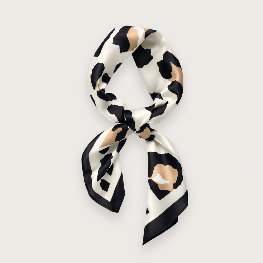 Matilda satintørklædet har et grafisk leopardinspireret dyreprint i creme, sort og varme beige toner – et nordisk, clean take på dyreprint-trenden. Udtrykket er roligt og stilrent med lige præcis nok kant til at løfte outfittet. Et kvadratisk tørklæde i satin, der er nemt at style til både minimalistiske hverdagslooks og mere skarpe, moderne outfits.

Satinen tilfører diskret glans, som minder om silke og falder smukt, når tørklædet bindes.

silketørklæde med leoprint - satin tørklæde - kvadratisk tørklæde