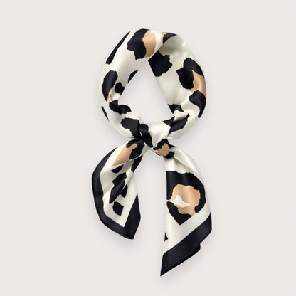 Matilda satintørklædet har et grafisk leopardinspireret dyreprint i creme, sort og varme beige toner – et nordisk, clean take på dyreprint-trenden. Udtrykket er roligt og stilrent med lige præcis nok kant til at løfte outfittet. Et kvadratisk tørklæde i satin, der er nemt at style til både minimalistiske hverdagslooks og mere skarpe, moderne outfits.

Satinen tilfører diskret glans, som minder om silke og falder smukt, når tørklædet bindes.

silketørklæde med leoprint - satin tørklæde - kvadratisk tørklæde