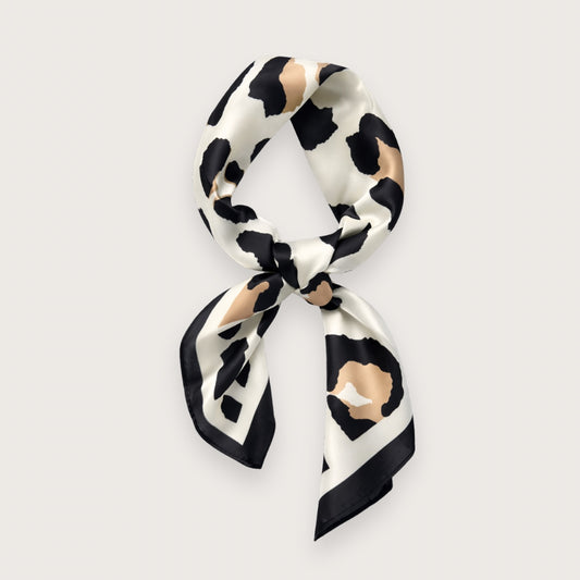 Matilda satintørklædet har et grafisk leopardinspireret dyreprint i creme, sort og varme beige toner – et nordisk, clean take på dyreprint-trenden. Udtrykket er roligt og stilrent med lige præcis nok kant til at løfte outfittet. Et kvadratisk tørklæde i satin, der er nemt at style til både minimalistiske hverdagslooks og mere skarpe, moderne outfits.

Satinen tilfører diskret glans, som minder om silke og falder smukt, når tørklædet bindes.

silketørklæde med leoprint - satin tørklæde - kvadratisk tørklæde