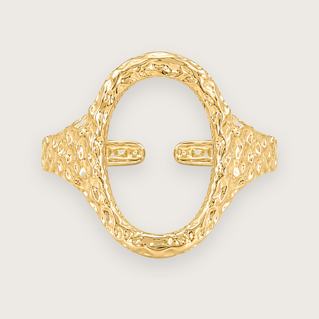 Forgyldt oval ring i rustfrit stål med banket overflade

Elvira-ringen er designet med en markant organisk silhuet og en åben oval front, der giver ringen et mere skulpturelt udtryk end klassiske guldringe. Den hamrede overflade skaber ujævne refleksioner i metallet og giver ringen mere dybde, struktur og karakter fra alle vinkler.

Elvira er en guldring, der tilfører form, struktur og mere kant til selv en enkel styling.

Ringen er fremstillet i rustfrit stål med vandfast PVD-forgyldning

oval ring