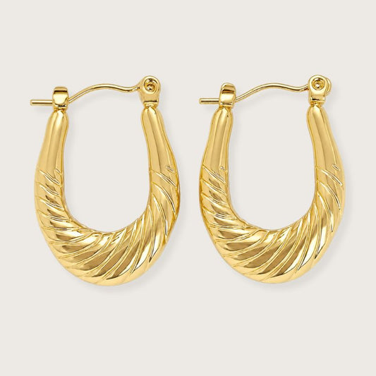 18k forgyldte øreringe med vandfast PVD-belægning

Lolie-øreringene er klassisk design og vintage elegance.

Øreringenes U-formede silhuet er let genkendelig og tidløs, mens den snoede overflade tilføjer struktur og karakter.

De forgyldte øreringe er fremstillet i rustfrit stål med vandfast 18k PVD-forgyldning.

Designet er smukt og klassisk i sig selv, men kan med fordel stackes med andre smukke guldøreringe for et mere personligt udtryk.