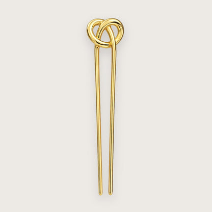 Cady er en elegant fransk hårnål med et skulpturelt og enkelt udtryk, hvor den dekorative knude i toppen giver et diskret, men iøjnefaldende twist. Den glatte, guldfarvede overflade reflekterer lyset smukt og tilfører et eksklusivt præg, uanset om håret er sat op eller bæres mere løst og afslappet.

Hårnålen er fremstillet i guldfarvet metal og måler ca. 12,3 cm i længden og ca. 3 cm i bredden ved toppen, og med en vægt på ca. 27 g føles den solid og behagelig i håret. fransk hårnål guld