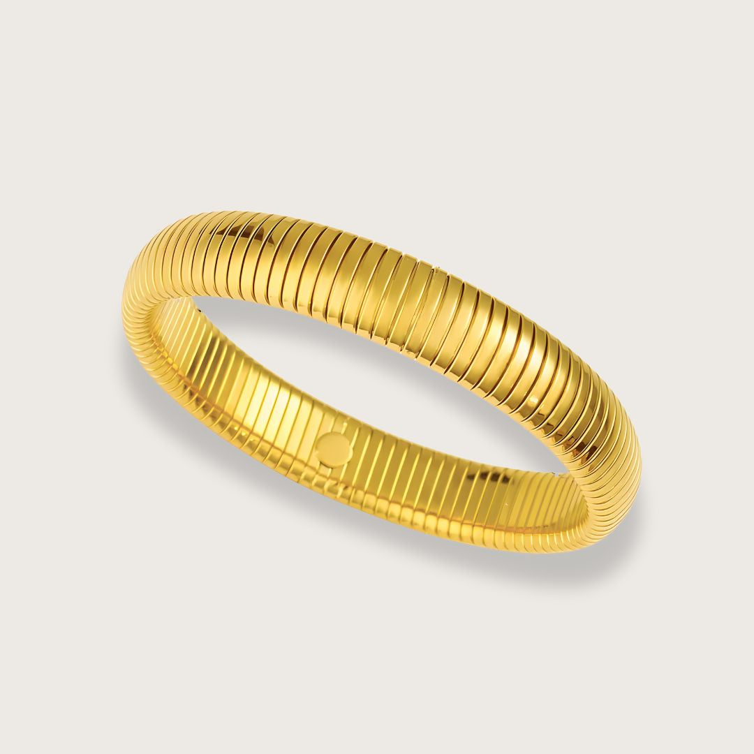 En smuk, forgyldt bangle (eller armring, som de også kaldes), bidrager med et eksklusivt udtryk og er det perfekte match med andre guldarmbånd.

Béa er en klassisk guldbelagt armring, der kan styles på mange måder. Kombiner med andre armbånd eller armringe for et sammensat, personligt udtryk, eller style armringen uden på sweateren for et mere trendy look.&nbsp;

Armbåndet er vandfast og tåler vand, sved og parfume.