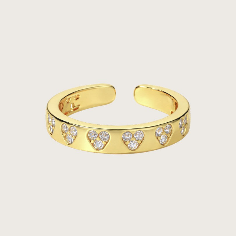 18k forgyldt ring med små zirkonhjerter

Den forgyldte hjertering har et let og elegant udtryk med små klare zirkoner, der former en række diskrete hjerter.

Designet giver et fint spil i lyset og gør ringen velegnet både til hverdag og som en fin detalje til fest eller på særlige mærkedage.

Ringen er åben og fungerer som en justerbar ring, der nemt kan tilpasses forskellige fingerstørrelser. Zirkonringen kan bæres på flere fingre og er derfor nem at stacke med andre flotte guldringe.
