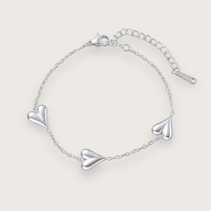 Smukt hjertearmbånd med vandfast sølvbelægning.

Inès hjertearmbåndet er et klassisk smykke med moderne kant til de dage, hvor du lige vil udstråle dét ekstra.&nbsp;

Det tynde armbånd og hjerternes tyngde skaber en elegant kontrast, der kan løfte ethvert outfit.

Inés-armbåndet findes også som halskæde.

Armbåndet er er fremstillet i sølvbelagt rustfrit stål. Belægningen er vandfast og slidstærk.Hjertearmbåndet er justerbart og måler ca. 17 cm + 5 cm forlængerkæde.