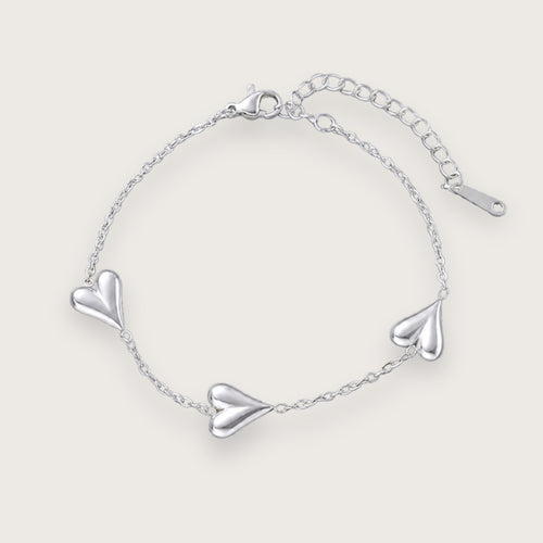 Smukt hjertearmbånd med vandfast sølvbelægning.

Inès hjertearmbåndet er et klassisk smykke med moderne kant til de dage, hvor du lige vil udstråle dét ekstra.&nbsp;

Det tynde armbånd og hjerternes tyngde skaber en elegant kontrast, der kan løfte ethvert outfit.

Inés-armbåndet findes også som halskæde.

Armbåndet er er fremstillet i sølvbelagt rustfrit stål. Belægningen er vandfast og slidstærk.Hjertearmbåndet er justerbart og måler ca. 17 cm + 5 cm forlængerkæde.