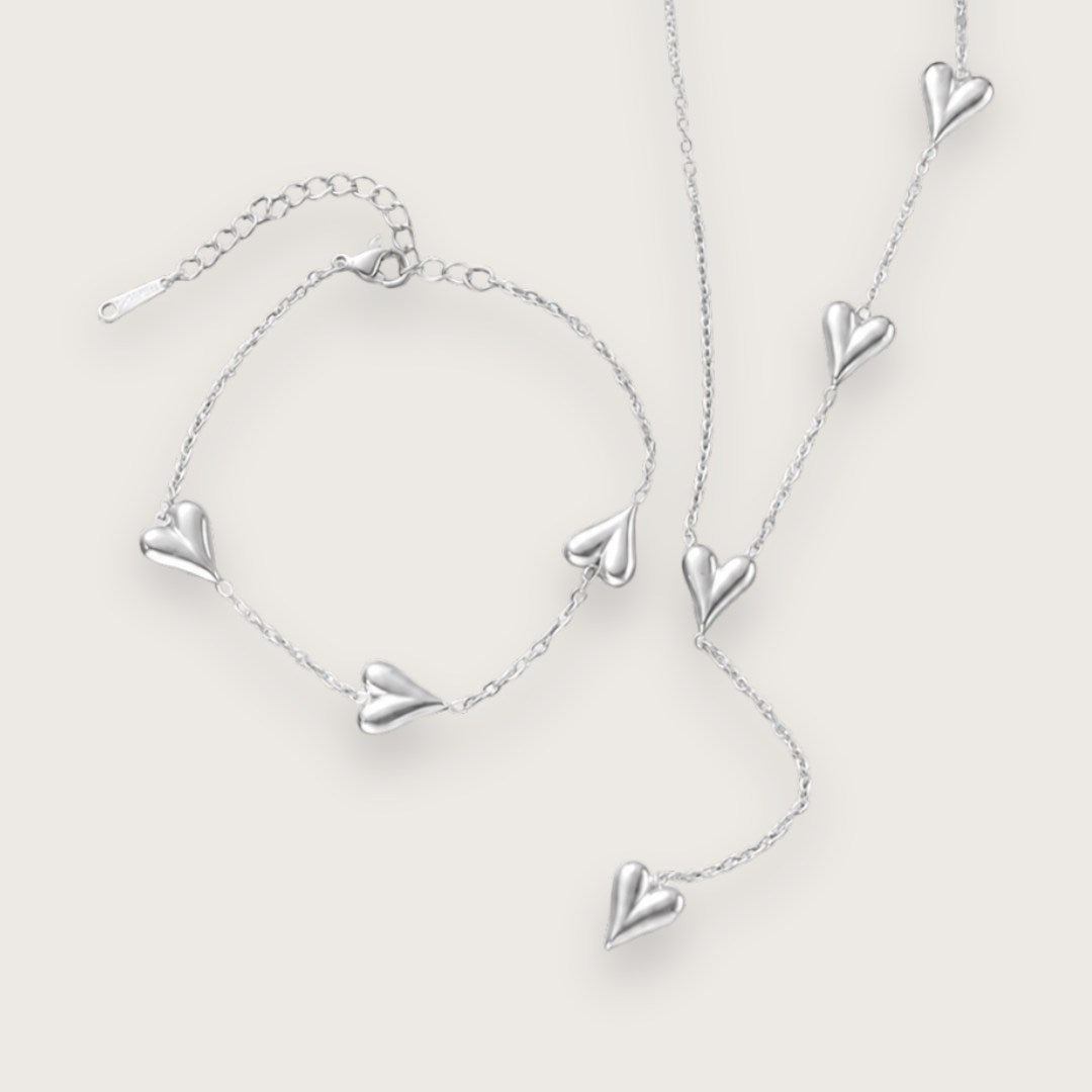 Smukt hjertearmbånd med vandfast sølvbelægning.

Inès hjertearmbåndet er et klassisk smykke med moderne kant til de dage, hvor du lige vil udstråle dét ekstra.&nbsp;

Det tynde armbånd og hjerternes tyngde skaber en elegant kontrast, der kan løfte ethvert outfit.

Inés-armbåndet findes også som halskæde.

Armbåndet er er fremstillet i sølvbelagt rustfrit stål. Belægningen er vandfast og slidstærk.Hjertearmbåndet er justerbart og måler ca. 17 cm + 5 cm forlængerkæde.
