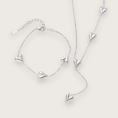 Smukt hjertearmbånd med vandfast sølvbelægning.

Inès hjertearmbåndet er et klassisk smykke med moderne kant til de dage, hvor du lige vil udstråle dét ekstra.&nbsp;

Det tynde armbånd og hjerternes tyngde skaber en elegant kontrast, der kan løfte ethvert outfit.

Inés-armbåndet findes også som halskæde.

Armbåndet er er fremstillet i sølvbelagt rustfrit stål. Belægningen er vandfast og slidstærk.Hjertearmbåndet er justerbart og måler ca. 17 cm + 5 cm forlængerkæde.