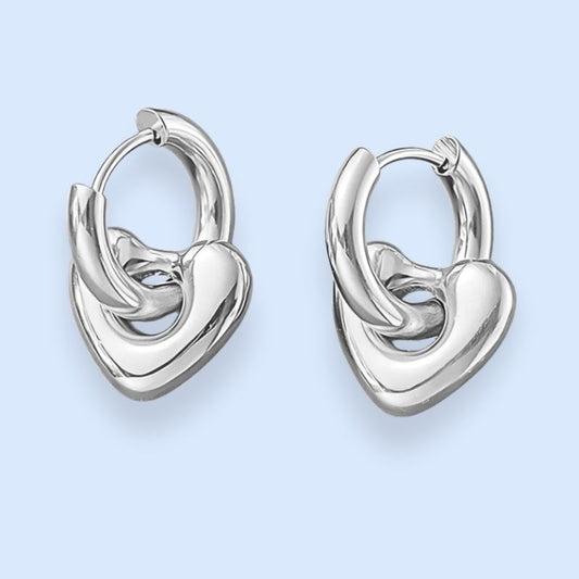 Hjertehoops med aftageligt vedhæng

Smukke hoop-øreringe med hjertevedhæng.&nbsp;

De fine sølvfarvede hjertehoops er et cool, chunky take på klassiske hjerteøreringe. Mindre cute, mere kant.

Annabel-hjerteøreringene kan dresse ethvert outfit op og fungerer til både hverdag, fest og alt derimellem. Formen er feminin, klassisk og cool på samme tid.