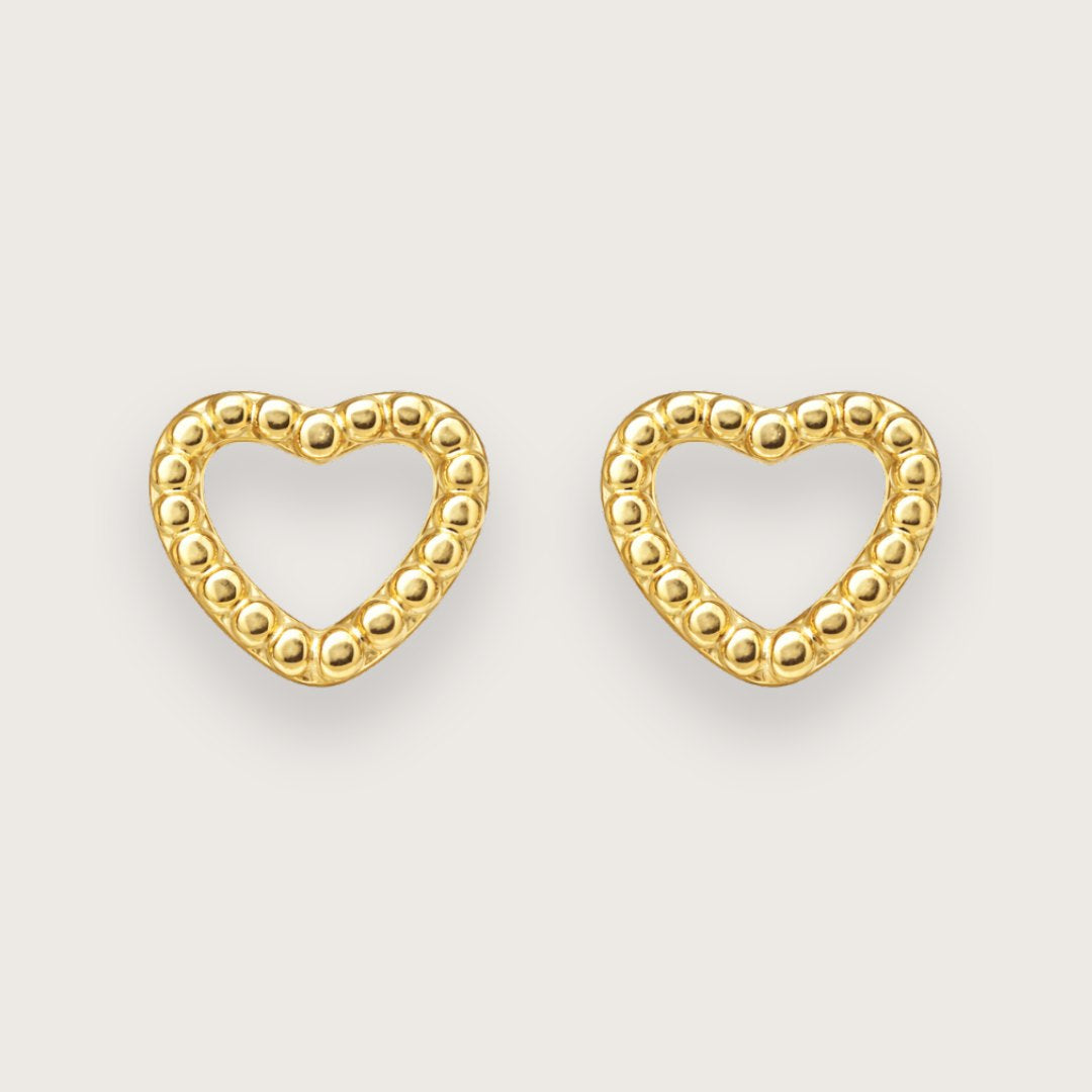 Disse fine hjerteørestikkere er designet som små, elegante studs med et enkelt og stilrent hjertemotiv.

Det lille hjerte giver øreringene et diskret symbolsk udtryk, samtidig med at designet forbliver let og minimalistisk. Resultatet er et par små øreringe, der fungerer både til hverdag og til konfirmationer.

Smykker til konfirmation, studenterfest, bryllup, hverdag.

Ørestikkerne er fremstillet i rustfrit stål med 18k PVD-forgyldning. vandfaste øreringe.

konfirmationsøreringe, konfirmation ørestikkere.