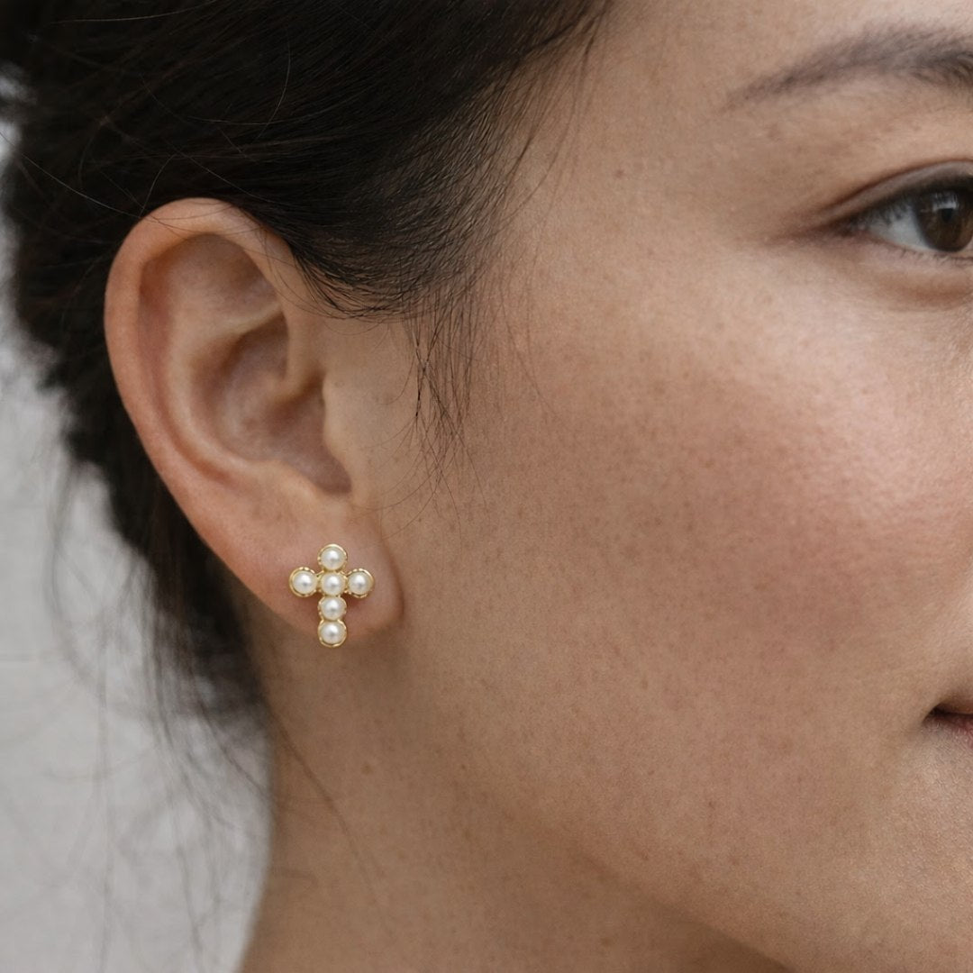 Disse elegante kors-ørestikkere er et elegant og trendy bud på det klassiske kors-motiv.

De små perleøreringe er oplagte som konfirmationsøreringe og konfirmationssmykker.

De små perler giver øreringene et luksuriøst og klassisk look, der passer til både minimalistiske outfits og mærkedage som bryllupper og konfirmationer. 

Smykker til konfirmation

Korsørestikkerne er fremstillet i rustfrit stål med 18k PVD-forgyldning. vandfaste øreringe.

kors øreringe, kors ørestikkere, konfirmationsøreringe