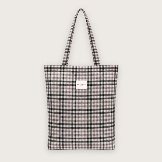 Lille tote bag med klassiske tern i sort og beige nuancer. Designet og syet i Spanien.

Nice er en skøn lille tote bag i tykt jacquardvævet stof.

Tasken er lavet til at følge dig gennem dagen – fra skole til café – og fungerer perfekt som både skoletaske, hverdagstaske og som en ekstra lille taske, der nemt kan pakkes væk og findes frem, hvis dagen byder på shopping eller den lidt mere kedelige form for indkøb.

Med en størrelse på 36 x 39 cm rummer den de fleste laptops