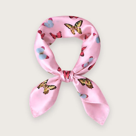 Lyserødt satintørklæde med sommerfugle i pink, blå og lilla nuancer. Y2K-inspireret satin scarf i silkeblanding med glossy finish og farverigt butterfly print. Trendy hårtørklæde og halstørklæde til kvinder, stylet med Scandinavian cool girl og Pinterest fashion vibe. Pink satintørklæde til styling om halsen, i håret eller på tasken. 60x60 cm satin tørklæde med 30% silke og 70% polyester.
Satin tørklæde med sommerfugle i 00'er-stil. Trendy satintørklæde. Lyserødt silketørklæde til halsen.
